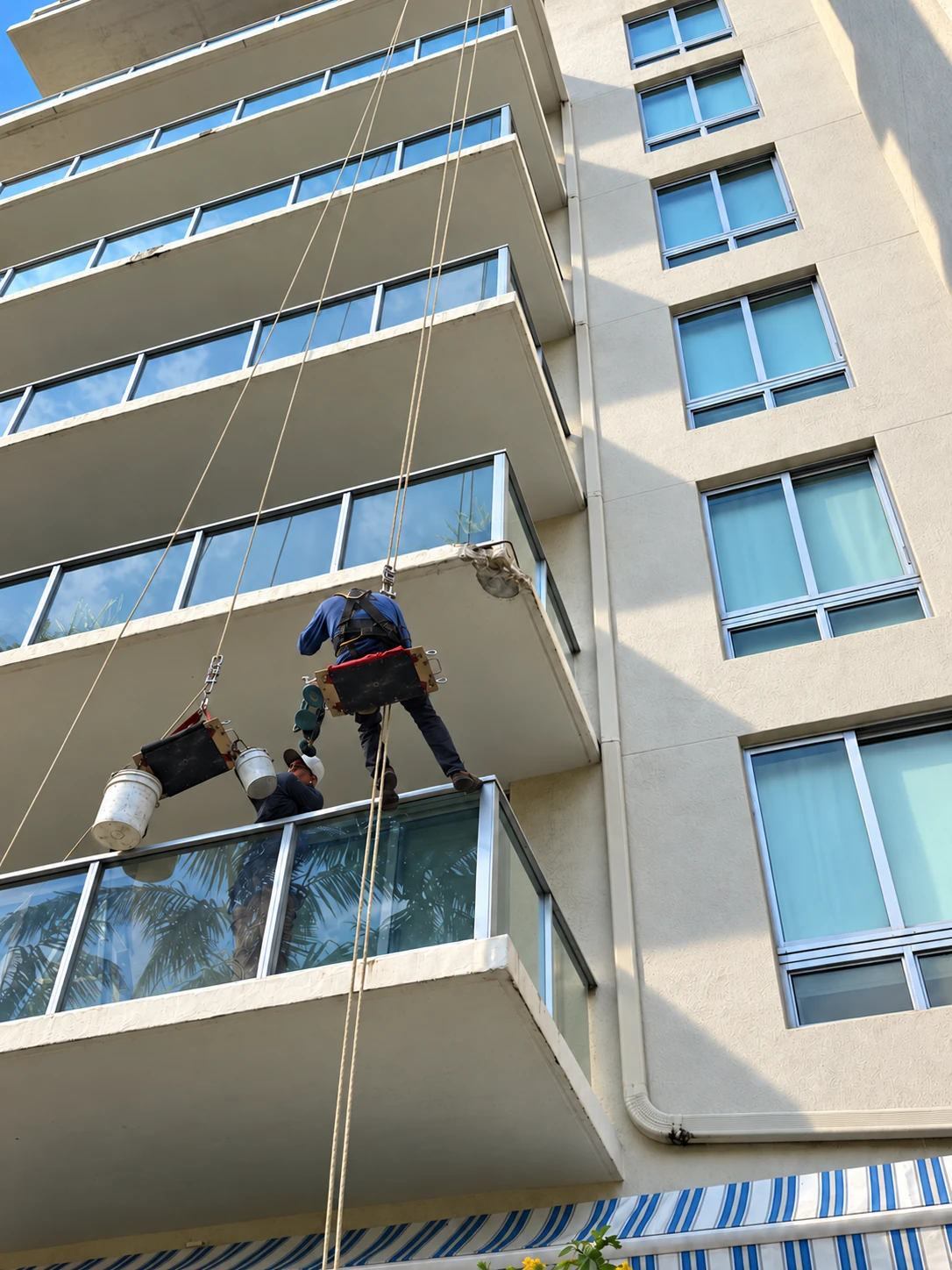 Técnico de High Point en silla bosun trabajando en los balcones de un edificio